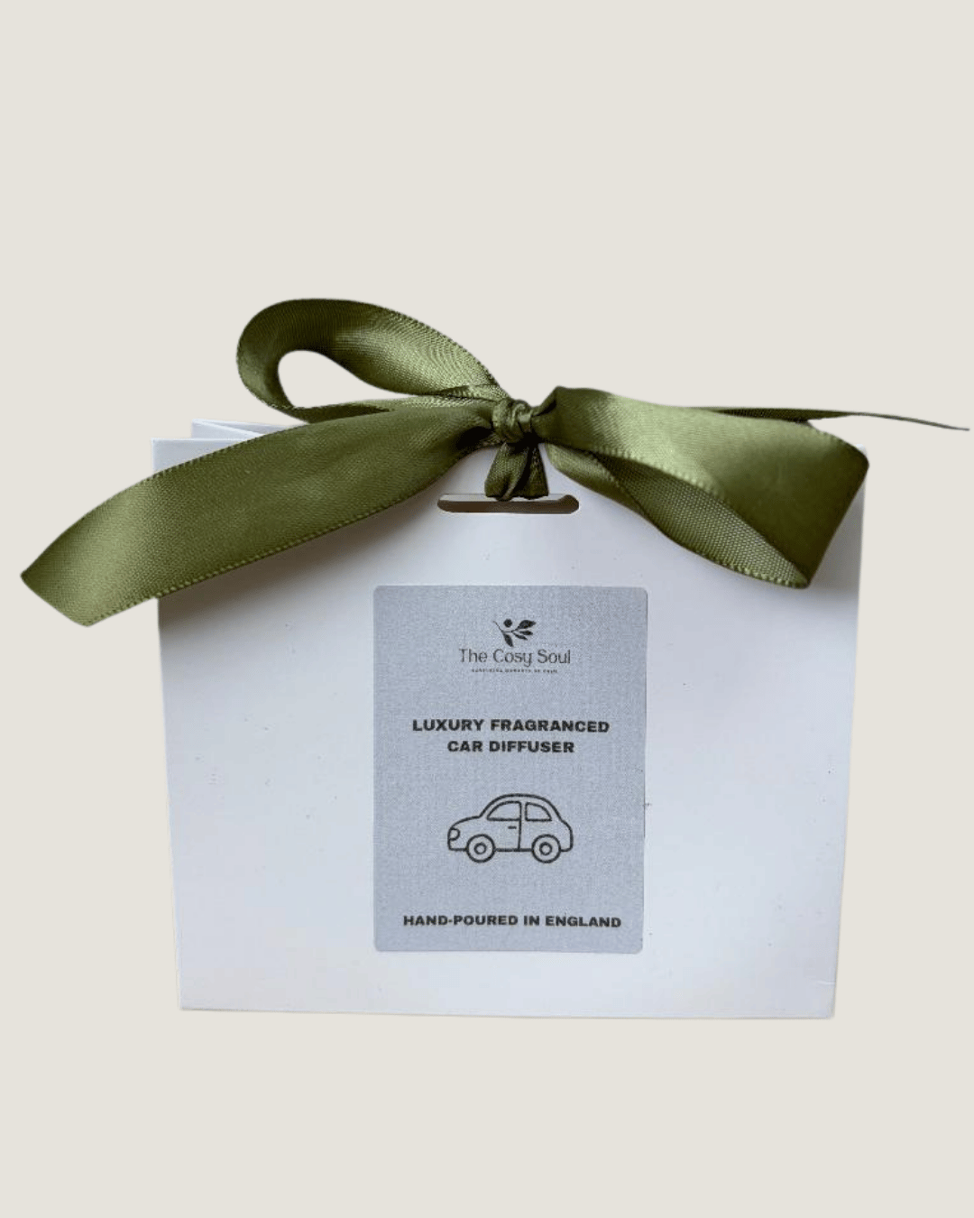 Luxury fragranced car diffuser in a white gift bag with a green ribbon