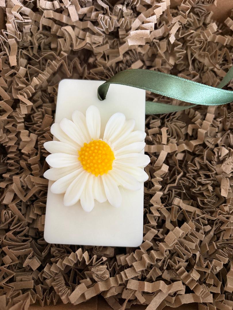 Wax Melt hanging with a daisy design on a brown crinkled paper background