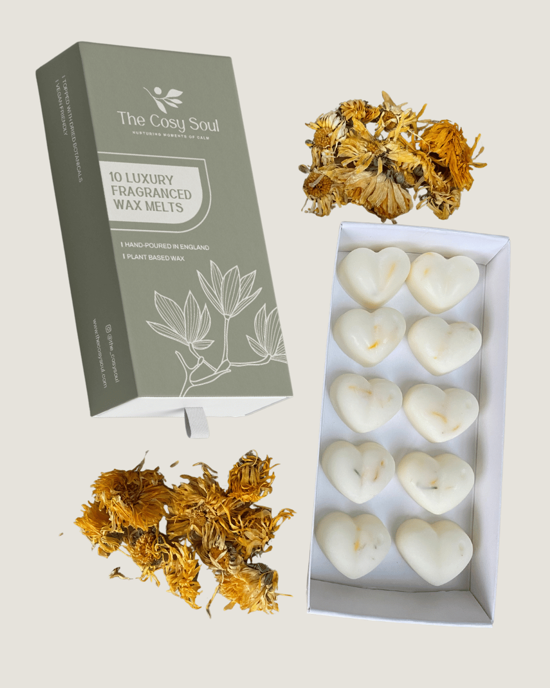 Box of heart-shaped honey and tobacco wax melts with 'The Cosy Soul' packaging and marigolds on a light background