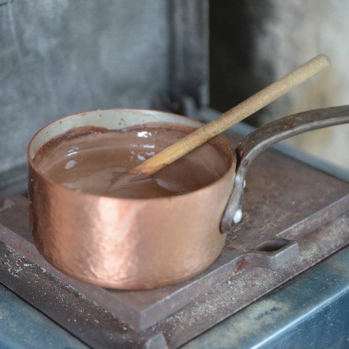 Hot chocolate mixing on a stove in a pan