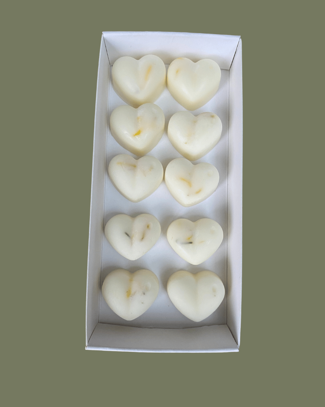Heart-shaped honey and tobacco wax melts in a white box on a green background