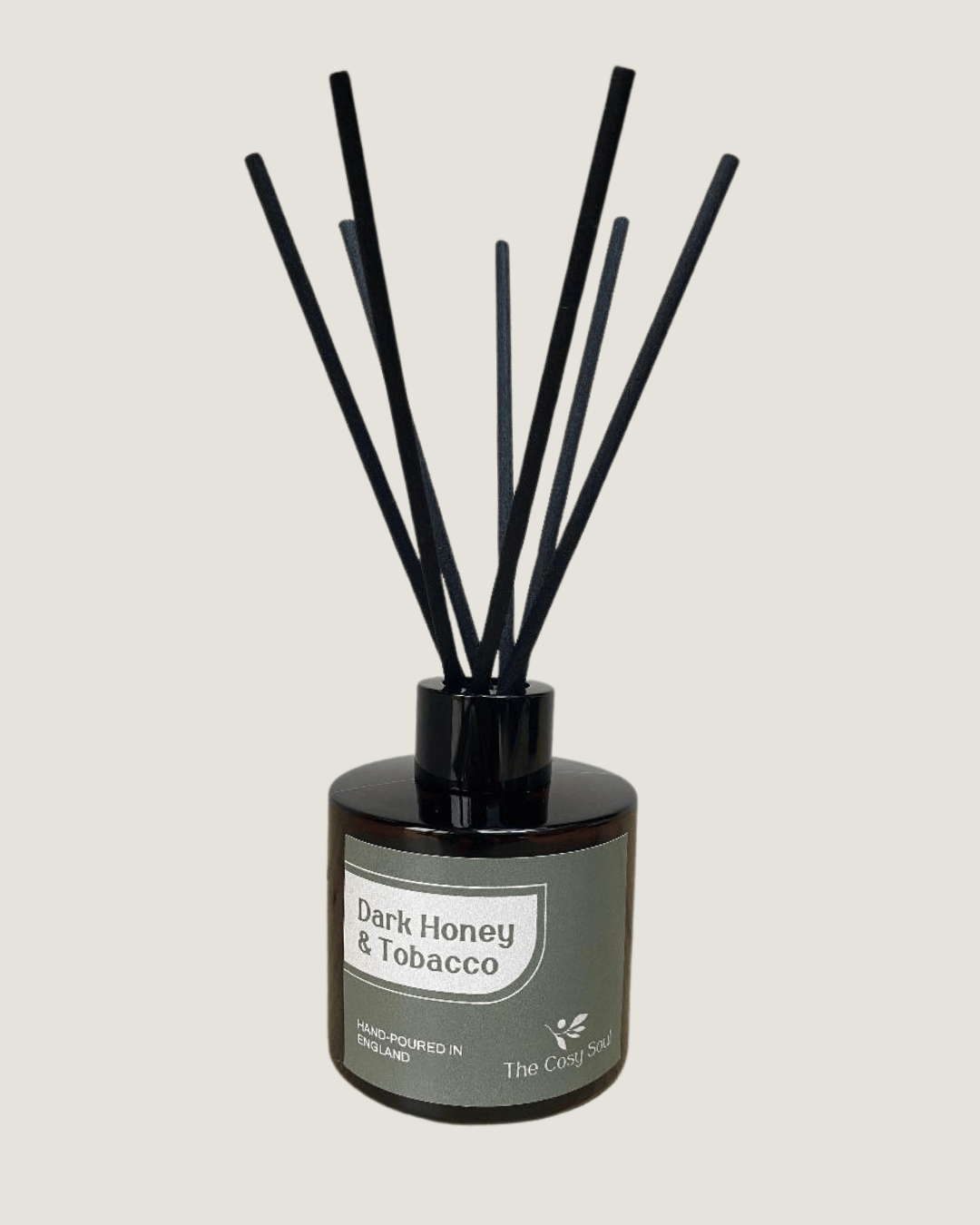 The Cosy Soul Diffuser with black reeds labelled 'Dark Honey & Tobacco' on a light grey background