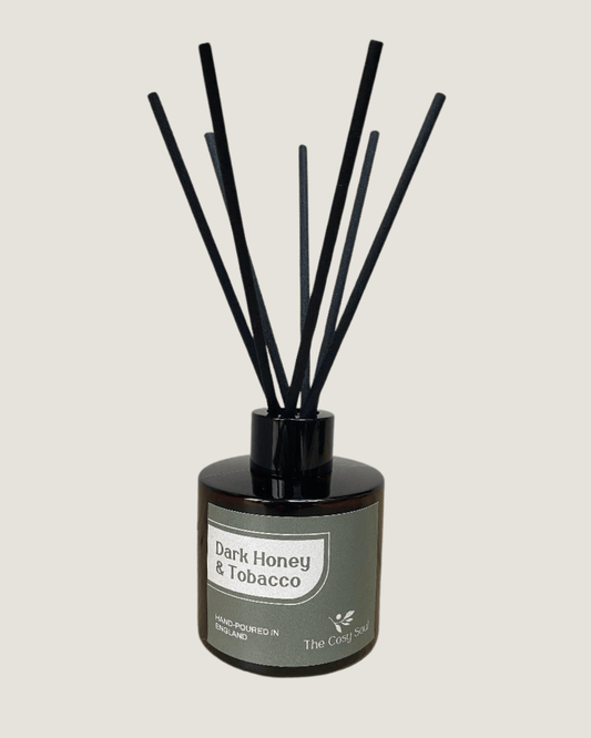 The Cosy Soul Diffuser with black reeds labelled 'Dark Honey & Tobacco' on a light grey background