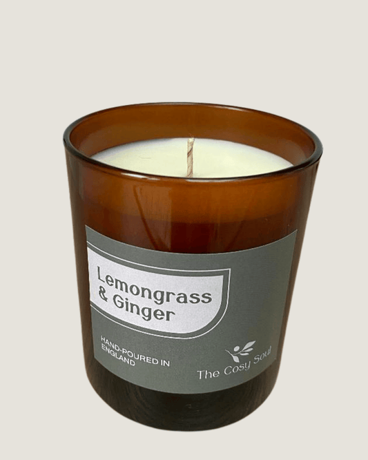 Lemongrass & Ginger candle in a brown glass jar with a label on a beige background