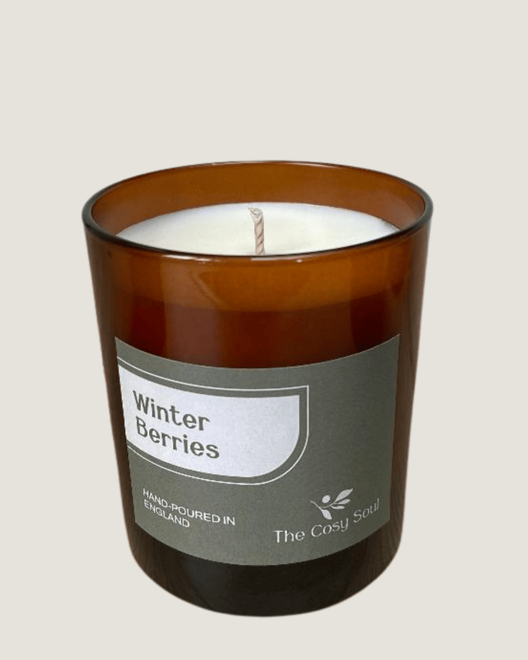 The Cosy Soul Winter Berries candle in a brown glass jar labelled 'Winter Berries' on a beige background
