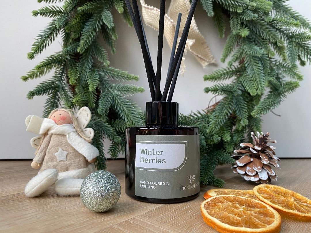 The Cosy Soul Diffuser labelled 'Winter Berries' with decorative elements on a wooden surface.