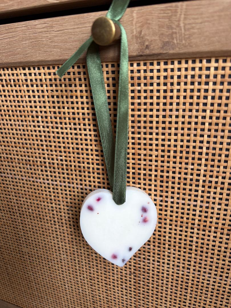 Hanging Wax Melt heart hanging on green ribbon and a wooden background