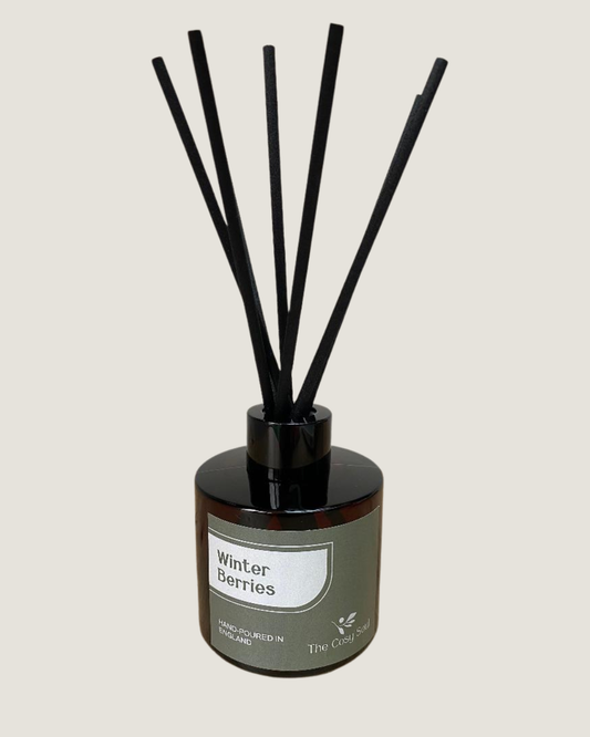 The Cosy Soul reed diffuser with black reeds labelled 'Winter Berries' on a light grey background